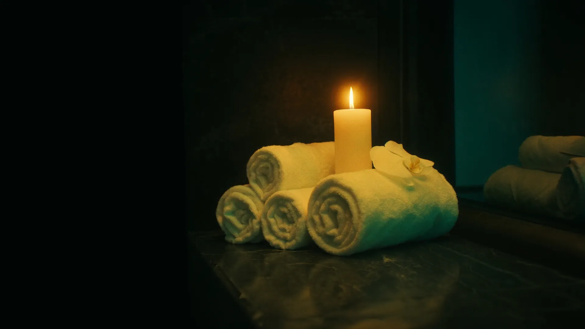 Rolled towels and a lit candle — the calm atmosphere of a Dipolog Massage session
